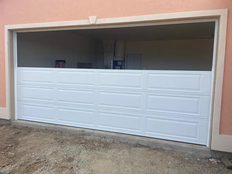 Garage door install in progress on a peach stucco house