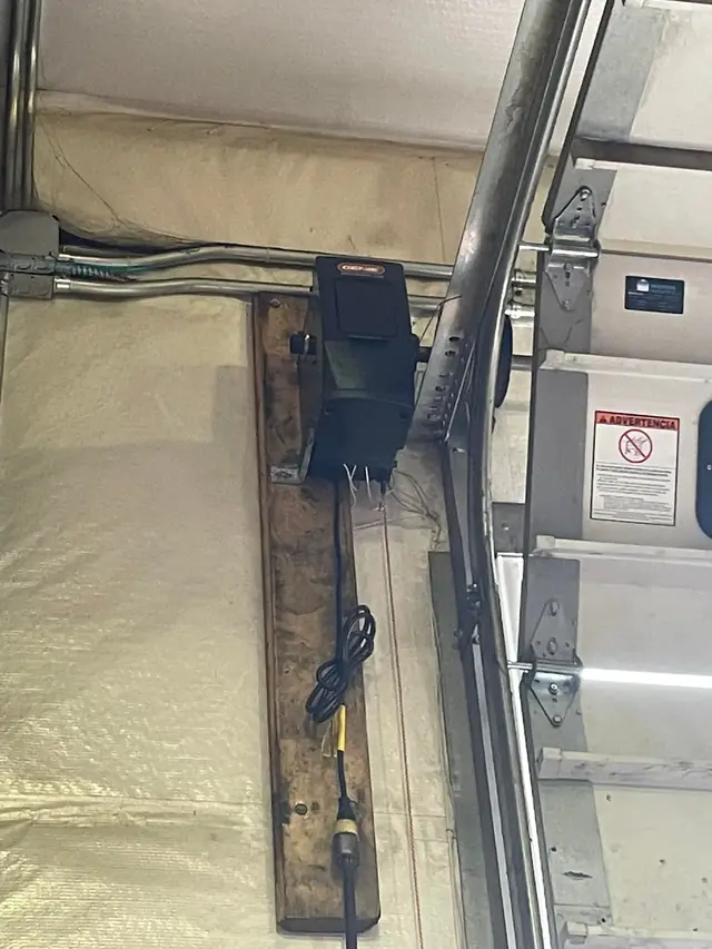 Wall-mount jackshaft opener installed beside the door track