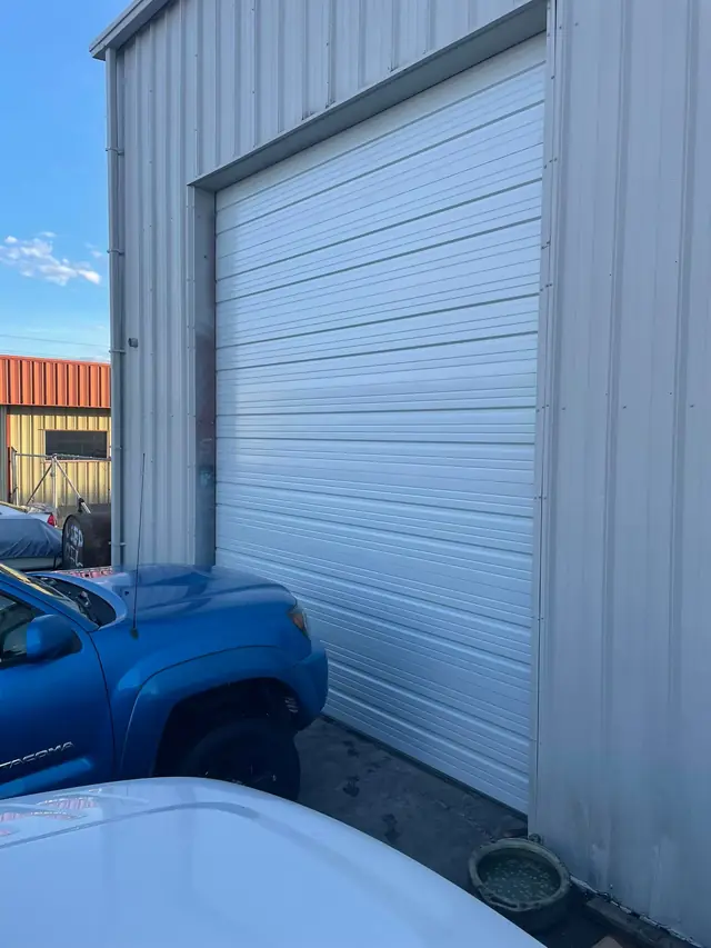 Tall white roll-up door on a metal building